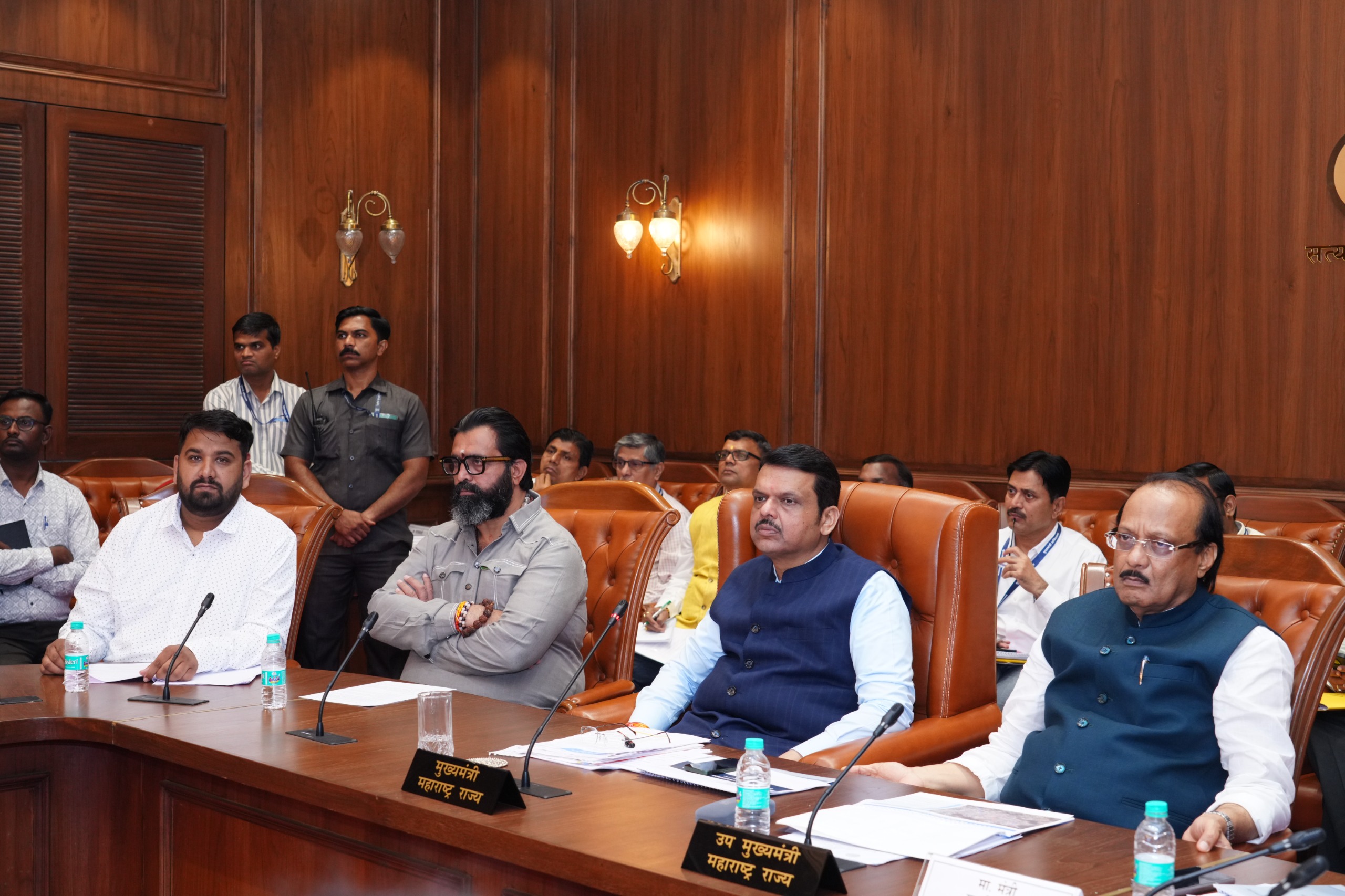 Conference room meeting with attendees seated around a long wooden table